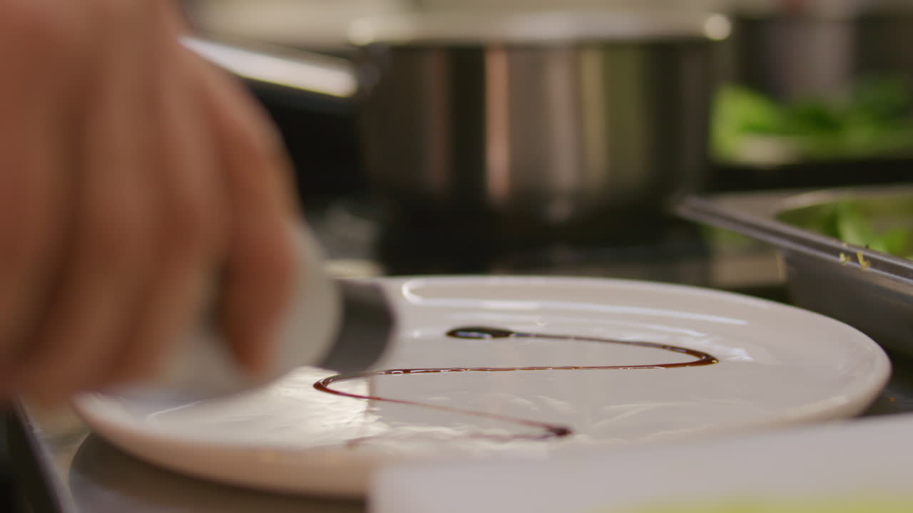 Chef Drizzling Balsamic Reduction on Plate while Serving Gourmet Dish