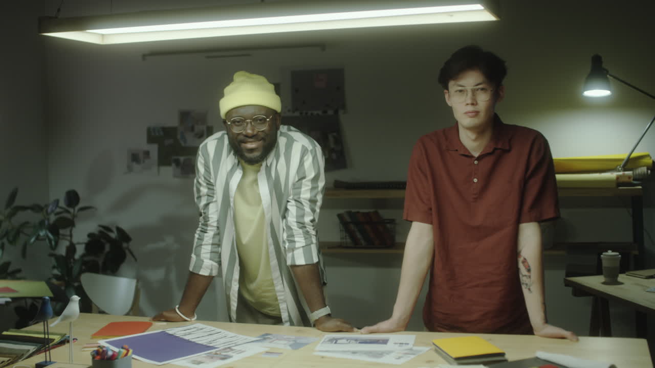 Two men standing at a desk in a creative office space
