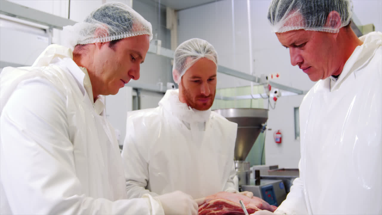 Male butcher maintaining records on clipboard