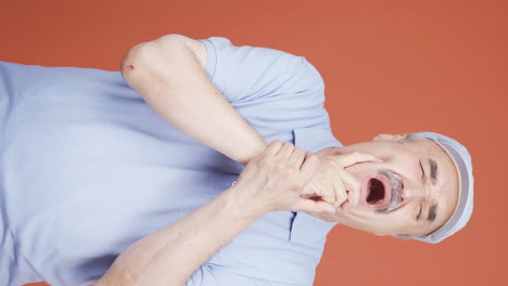 vertical video of old man with toothache.