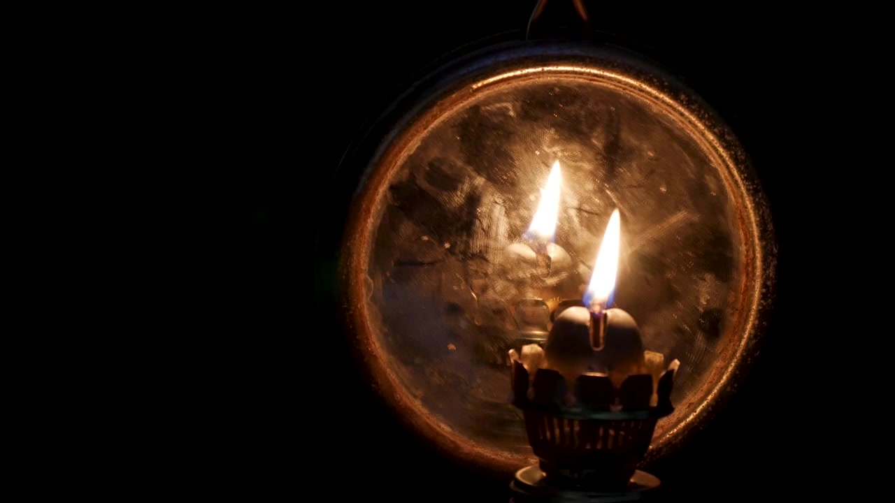 Primo piano dell'accensione di un'antica lampada a olio al buio.