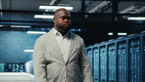 vertical video employee walking in data center with blinking lights on rigs
