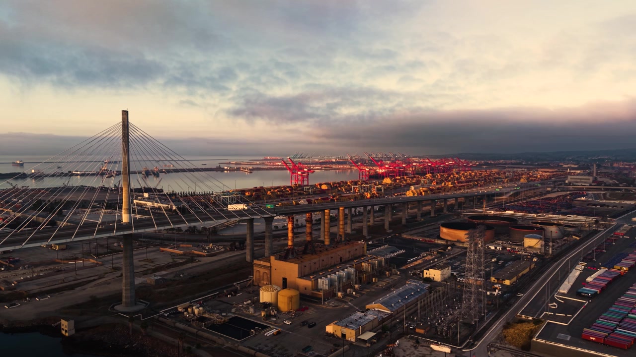 Pemandangan luas Jembatan Gateway di Long Beach menyingkap Pelabuhan Los Angeles yang masif pada pagi yang dingin dan berawan di musim semi.