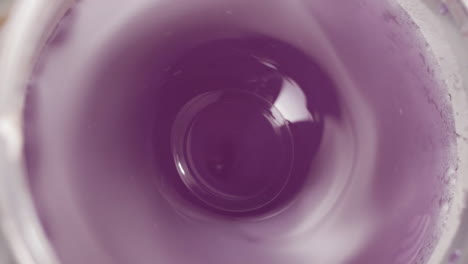 making fresh purple juicy drink, top view on working blender, 4k