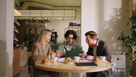 three colleagues meet for a business meeting at a cafe