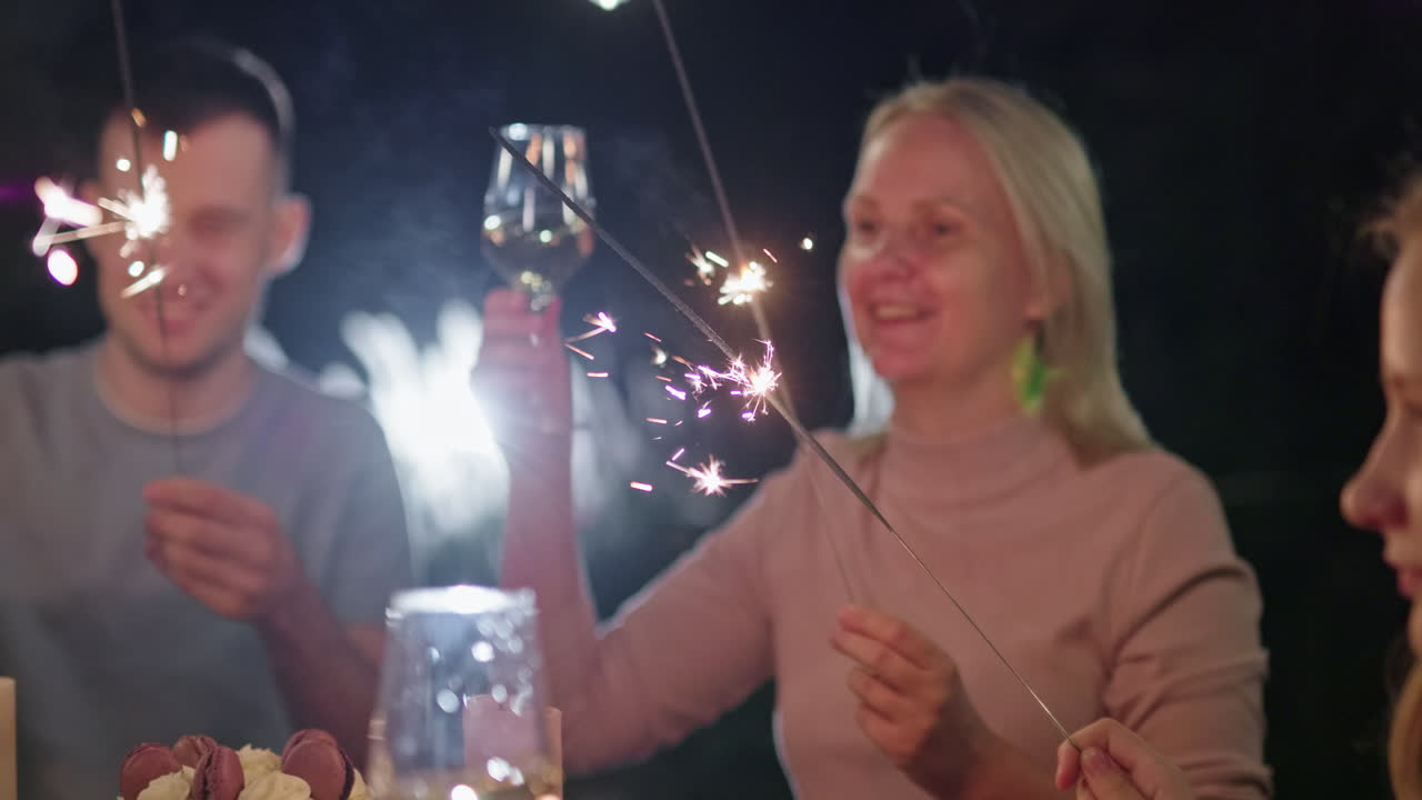 Freunde feiern mit Wunderkerze und Wein