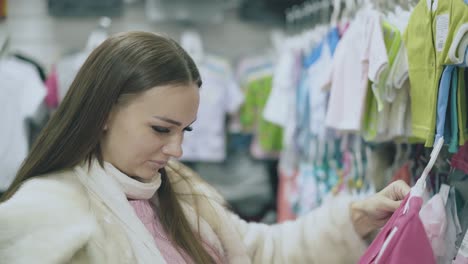 mujer bonita con aretes blancos lleva camiseta rosa para bebé