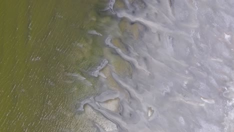 a 4k drone shot over the perfectly flat bonneville salt flats, found west of the great salt lake, in western utah, with a shallow layer of standing water flooding the vast salt plain’s surface