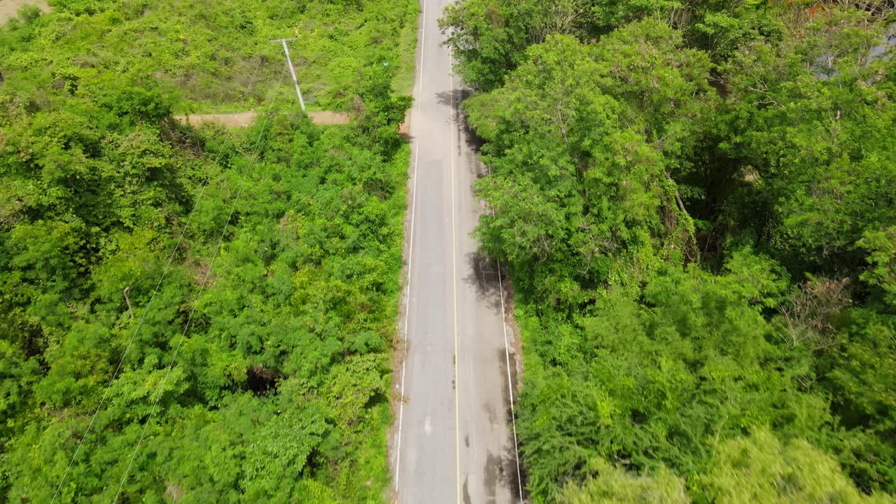 un metraje inverso tomado con un dron de la carretera que va en el parque nacional kaeng krachan, sitio del patrimonio mundial de la unesco, tailandia