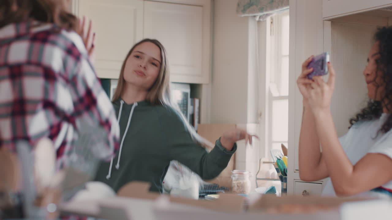 행복한 십대 소녀들이 부 ⁇ 에서 춤을 추고 피자를 먹고 즐겁게 함께 축하하며 주말을 즐기고 있습니다.