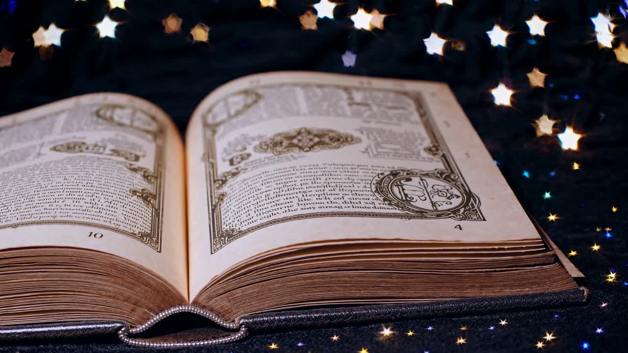 Волшебная книга, открытая на звездной ткани, снятая с низкого ракурса. Винтажный стиль создает мистическую