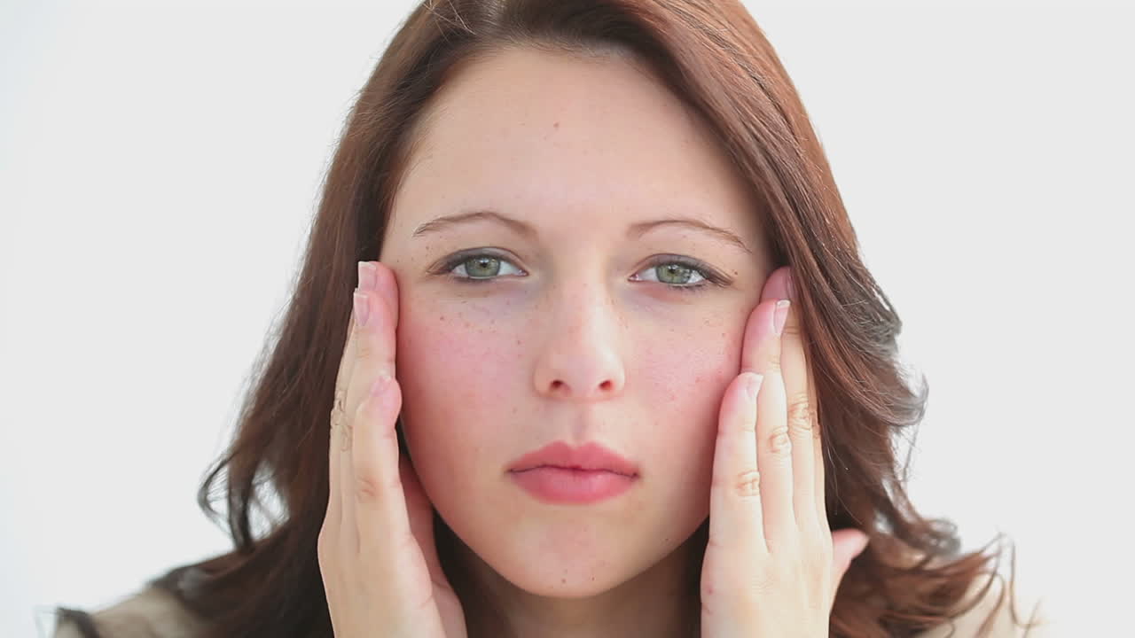 Serious brunette massaging her two cheeks