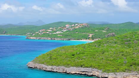 aerial pan reveals cas abou beach, christoffelberg, and beautiful blue sea water