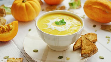 pumpkin soup in bowl served with bread