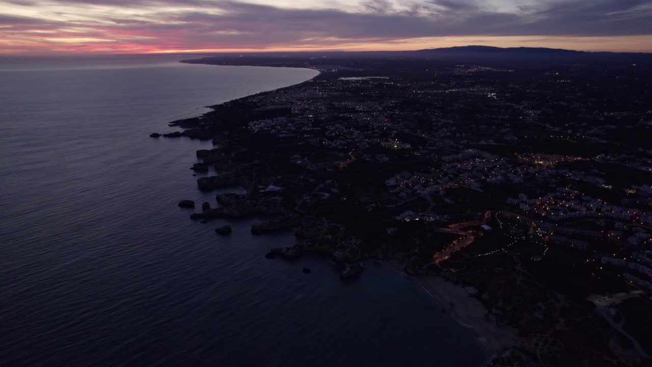 Tramonto sull'oceano vivace e la costa rocciosa di Albufeira a Faro