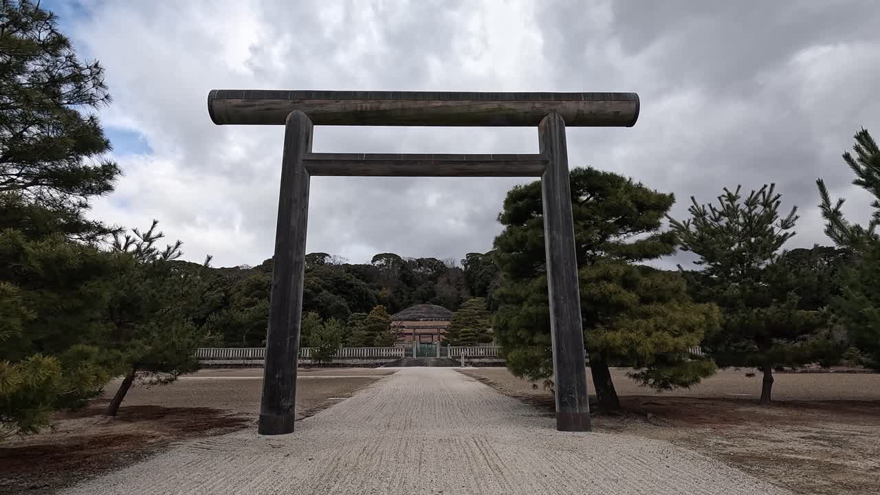 Stone Torii Gate Framing the Entrance to the Fushimi Momoyama Mausoleum of Emperor Meiji in Kyoto, Japan Under a Cloudy Sky