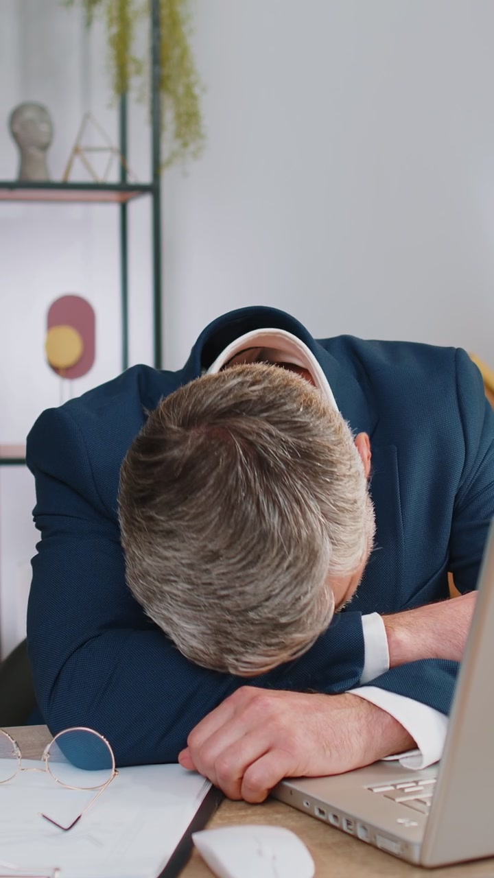 Uomo d'affari annoiato, addormentato, lavoratore che lavora al portatile, che sbadiglia, che si addormenta in ufficio.