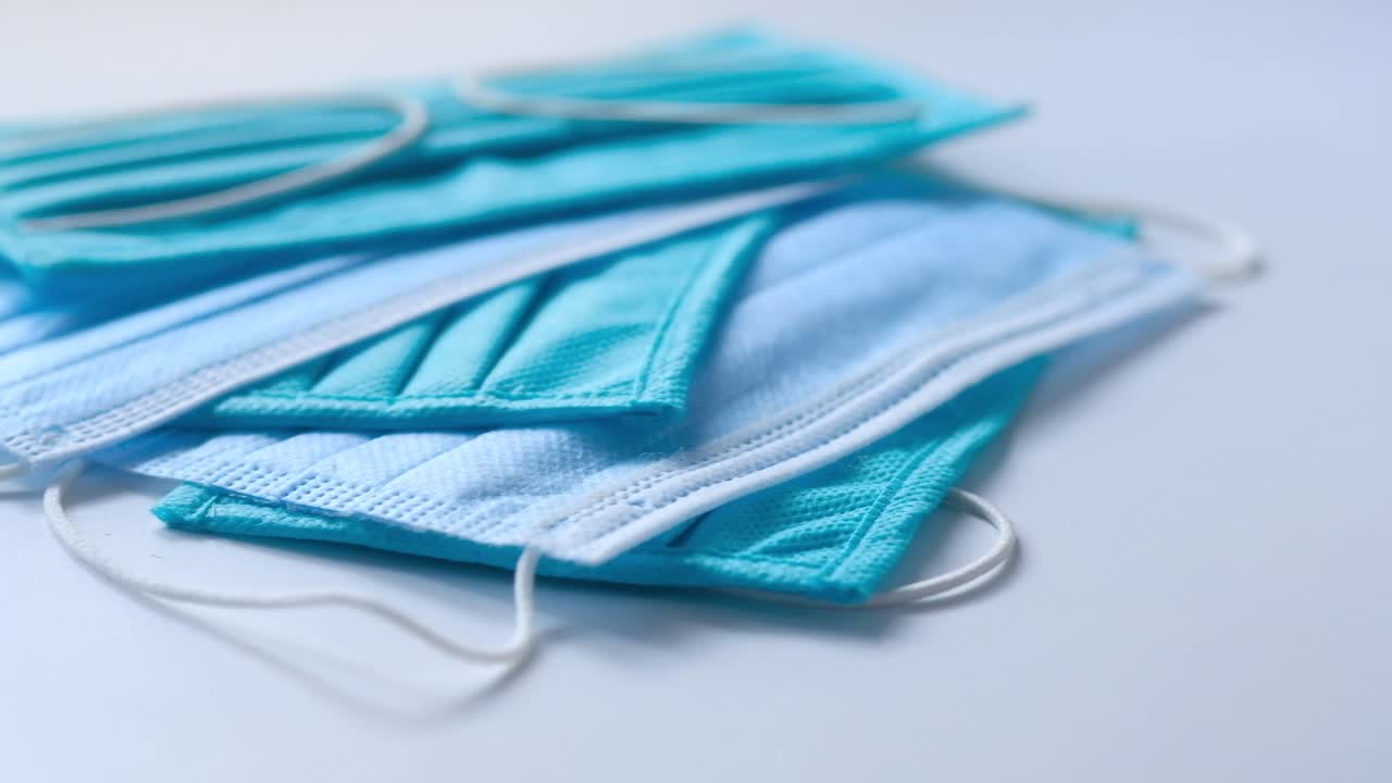 una pila de máscaras faciales desechables azules