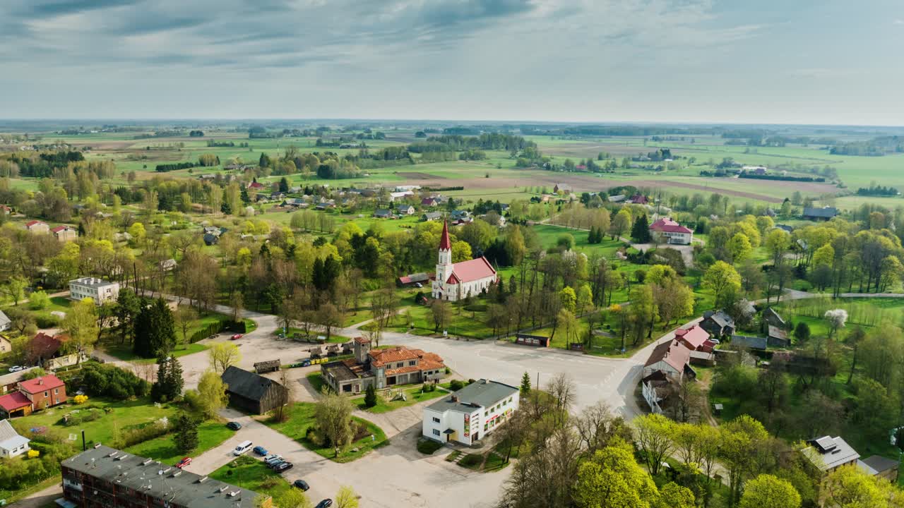Ilmahyperlapse uloszoomauksella, näyttäen Rucavan kylän Etelä-Kuurinmaalla, Latviassa.