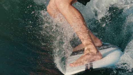 Male-wake-surfer-rides-wave-and-does-trick-in-slow-motion-with-water-splashing-around-him