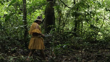 portrait of an indigenous man carrying a machete through the dense jungle in leticia, amazon, colombia