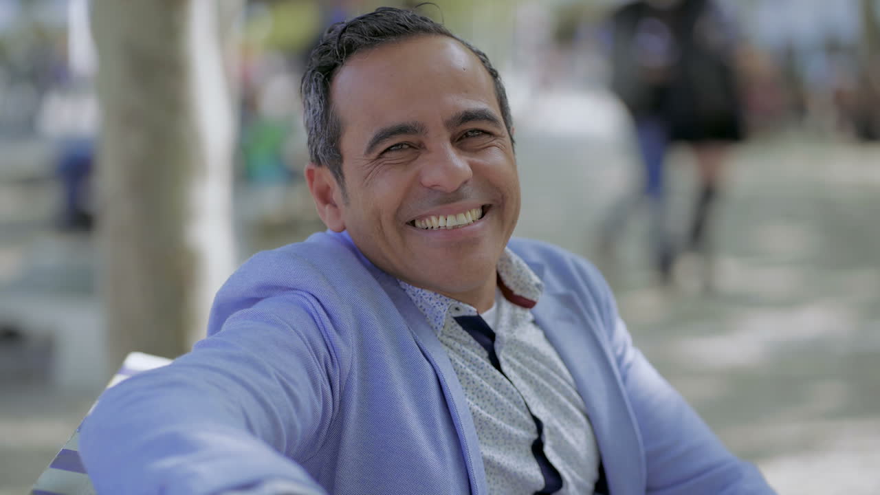 hombre maduro y guapo sonriendo a la cámara al aire libre