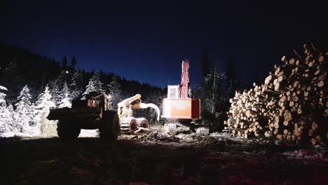 night time industrial wood logging operation machinery moving around