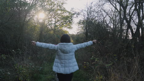 rear view of an asian woman stretching and walking down a country path