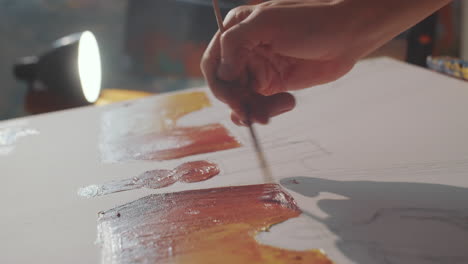 vertical shot of male artist painting on canvas