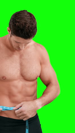 hombre musculoso midiendo su cintura