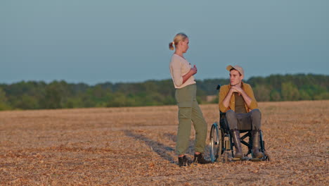 woman and man in wheelchair in a field