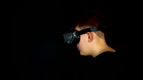 profile of young man wearing vr goggles virtual reality headset black background