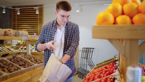 man shopping for produce in a grocery store