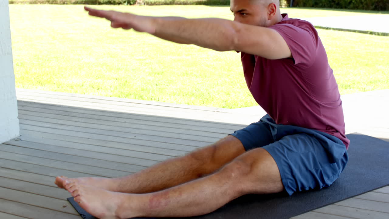 Homem praticando yoga no pátio, alongando os braços para cima, desfrutando de exercícios ao ar livre, com espaço para texto.