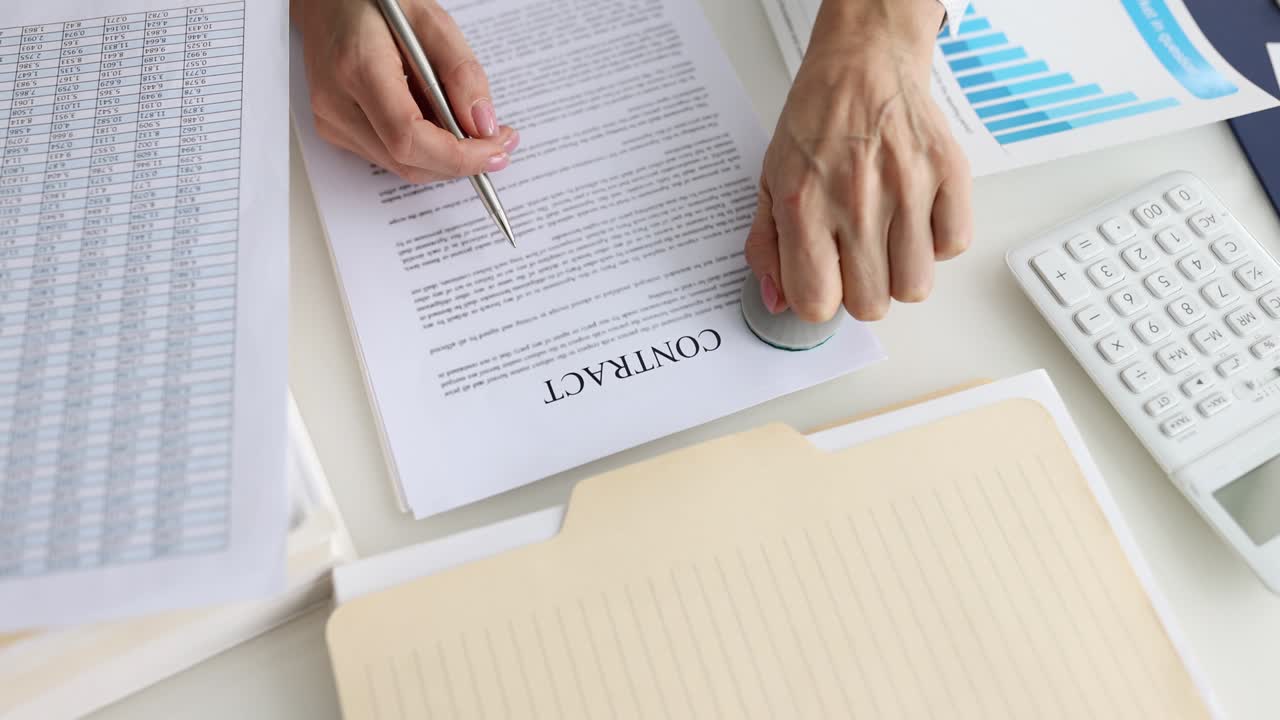 una mujer de negocios pone el sello "ok" en un contrato de negocios.
