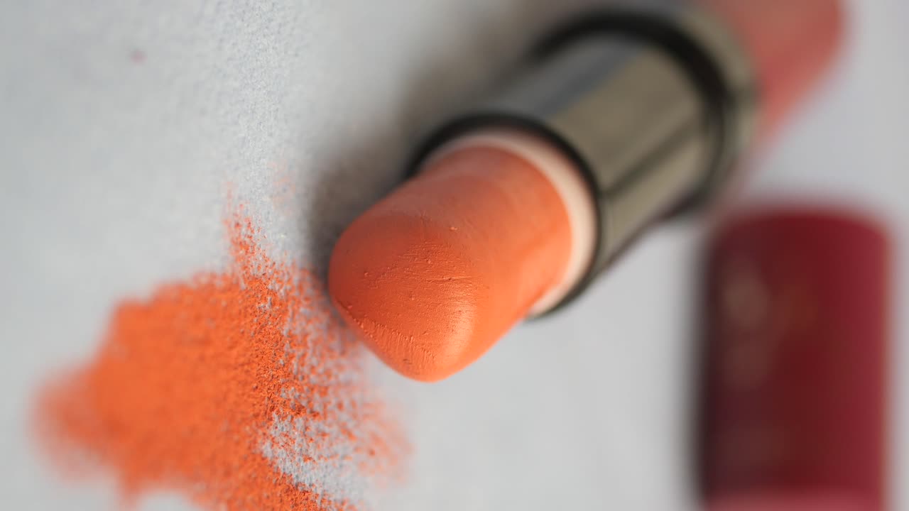 Close Up of Orange Lipstick with Scattered Powder