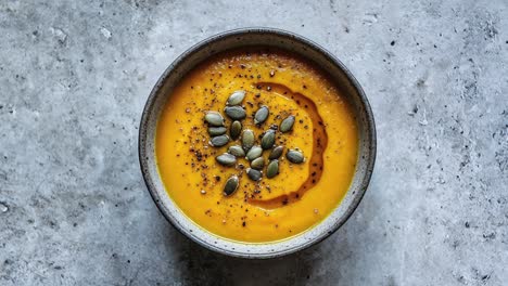 delicious pumpkin soup with roasted seeds in ceramic bowl