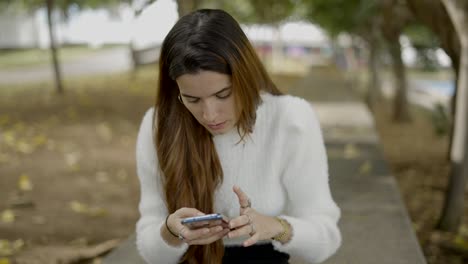 mujer usando un teléfono inteligente en un parque