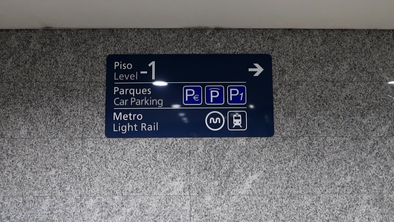 Skiltning for letbane og parkeringskælder på en væg i Porto Lufthavn, Portugal