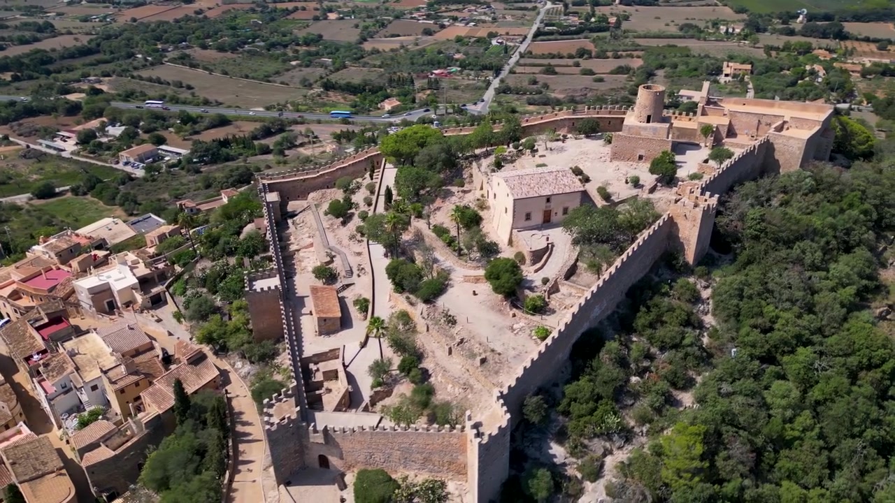 Aerial fly Castle of Capdepra on the hill above the small town of Mallorca Spain