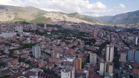 Medellin-skyline-with-mountains-backdrop,-Colombia---aerial-fly-over