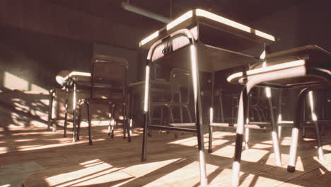 view to classroom with tables and small blackboard and grungy walls