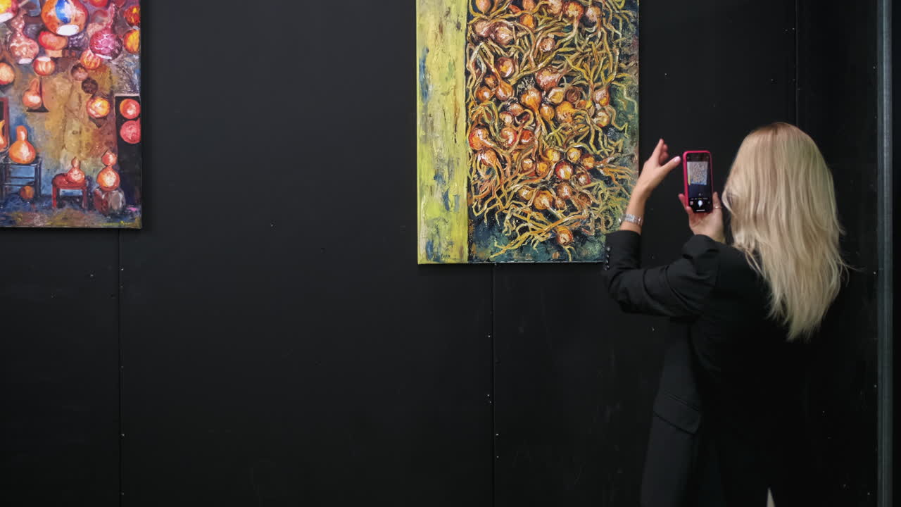 женщина фотографирует картину лука в художественной галерее