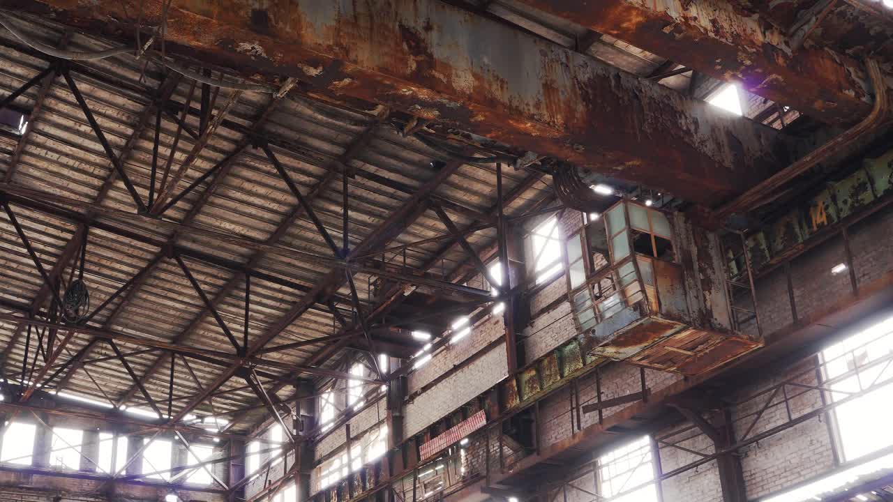 Old rusty metal ceiling in an abandoned factory hangar. Metal beams, structures of a broken industrial crane