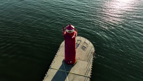 un faro rojo en contraste sorprendente contra las aguas verdes del lago michigan