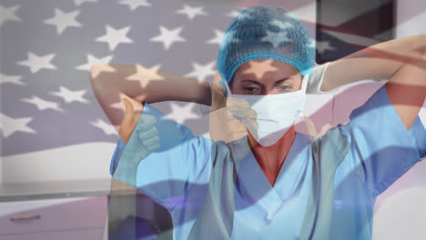 Animación-De-Ondear-La-Bandera-De-EE.UU.-Contra-Una-Cirujana-Birracial-Que-Usa-Una-Máscara-Quirúrgica-En-El-Hospital