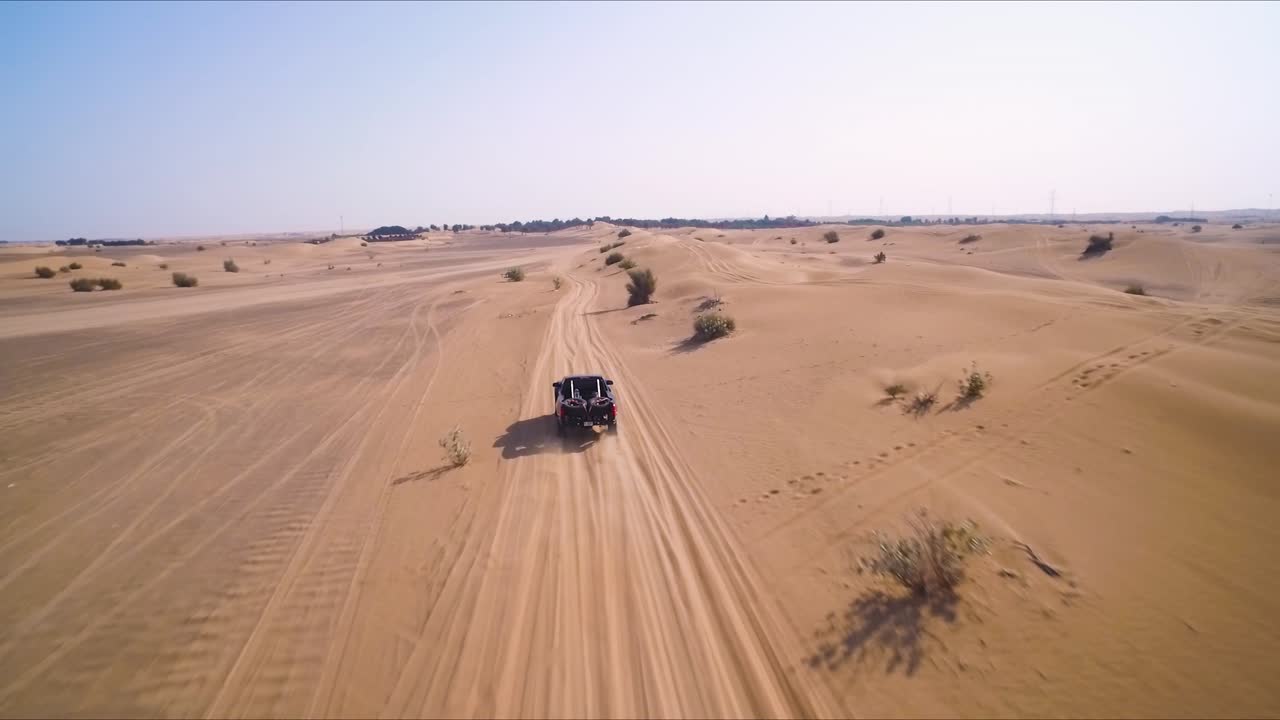 camiones 4x4 negros corren por un camino todoterreno cerca de las dunas de arena en el desierto a las afueras de dubai, emiratos árabes unidos