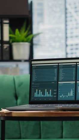 vertical video modern high end empty office space with a laptop running infographics