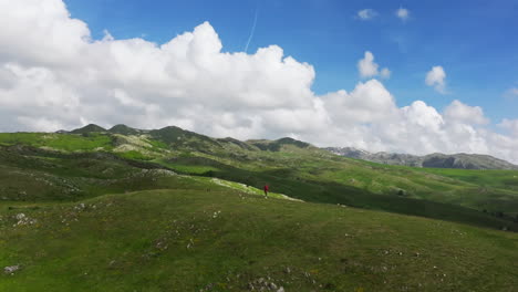mujer con chaqueta roja caminata exuberante montenegro montañas zabljak durmitov; avión no tripulado