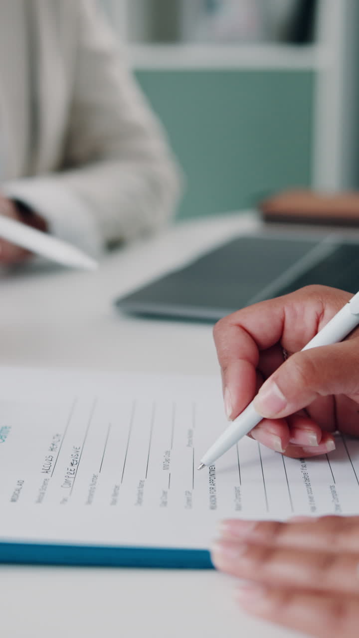 Primer plano de una mano escribiendo en un formulario con un bolígrafo
